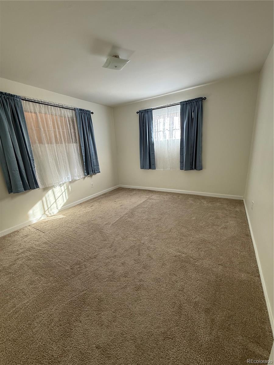 756 Vaughn Street Aurora, CO 80011 - Photo 5 of 22 a view of an empty room with window and stairs