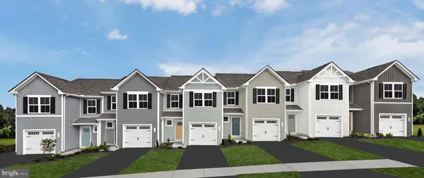 a front view of residential houses with yard and green space