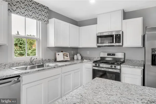 a kitchen with stainless steel appliances granite countertop a sink stove microwave and cabinets
