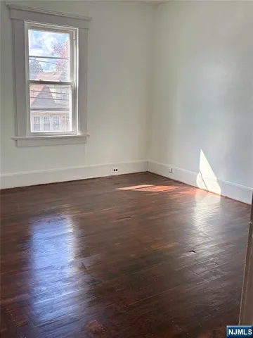 an empty room with wooden floor and entrance