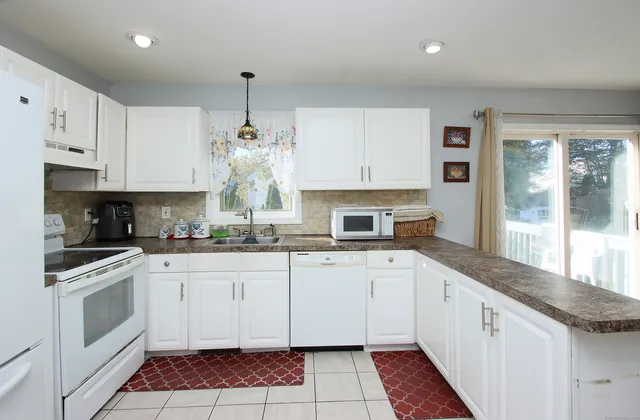 a kitchen with granite countertop a stove sink and cabinets