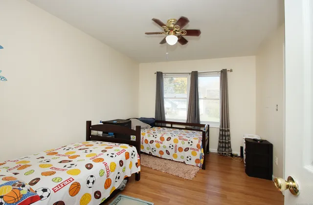 a bedroom with a bed and wooden floor