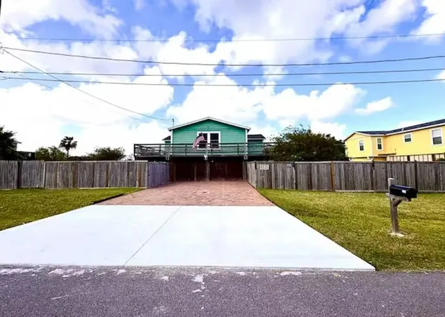 a view of a backyard with wooden fence