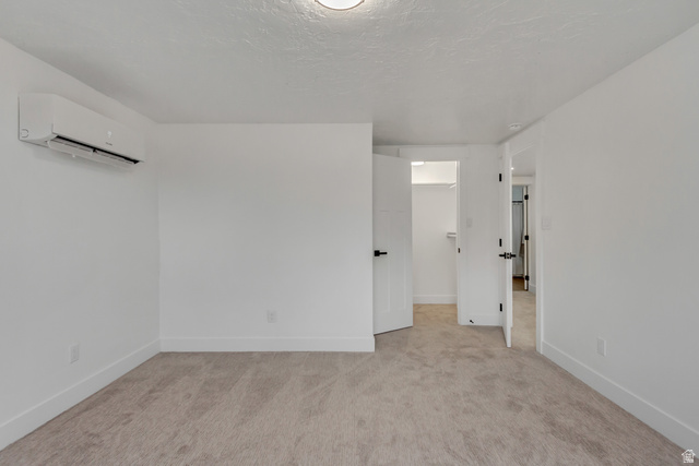337 West 2900th Street South Bountiful, UT 84010 - Photo 31 of 35 Spare room featuring carpet, a wall mounted mini split, and a textured ceiling