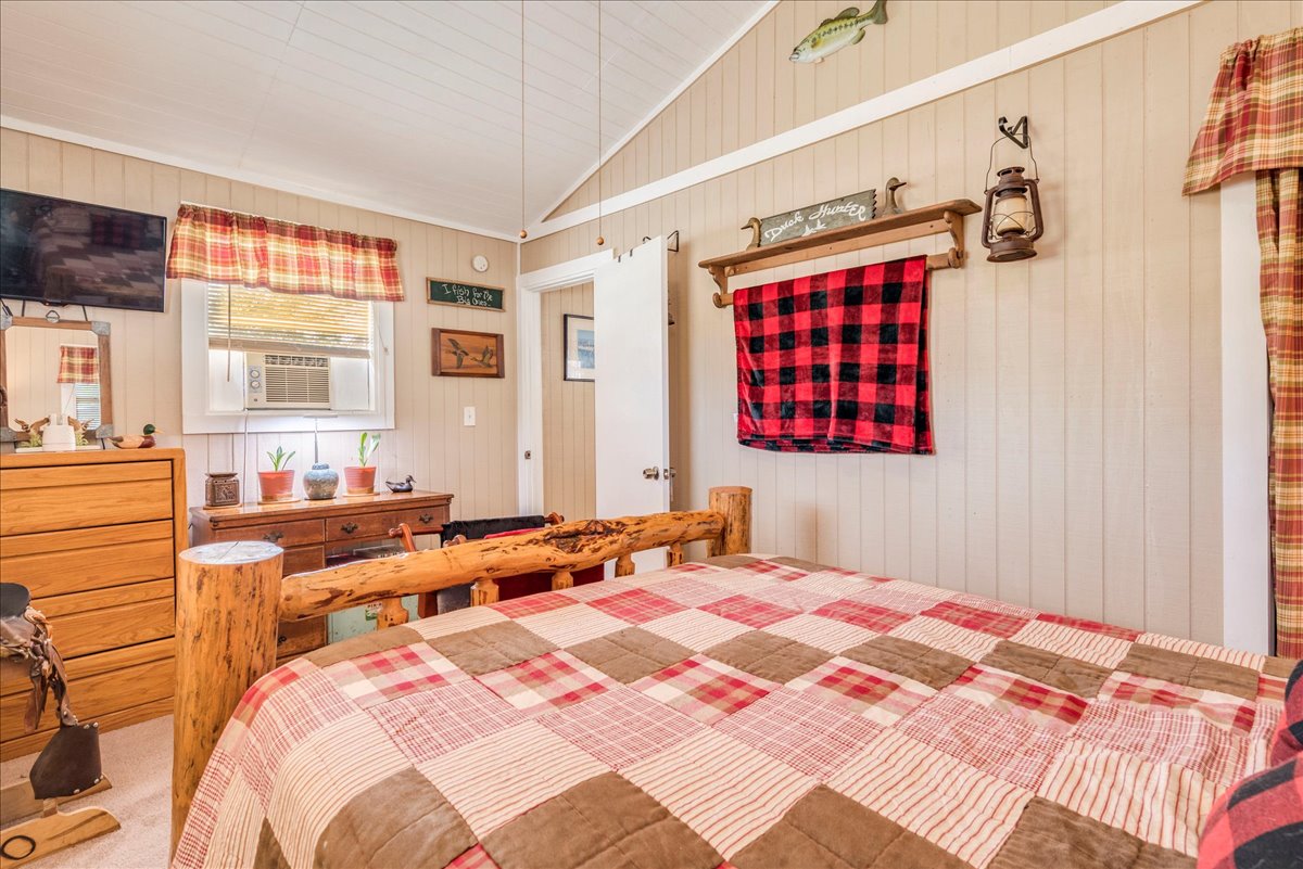 2411 Rohde Road Kyle, TX 78640 - Photo 27 of 40 Vaulted wood-paneled ceilings and rustic wooden walls define this cozy bedroom retreat.