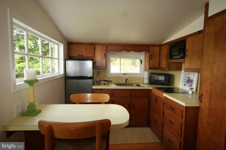 6857 Edge Creek Road St. Michaels, MD 21663 - Photo 11 of 13 a kitchen with a table chairs sink and cabinets