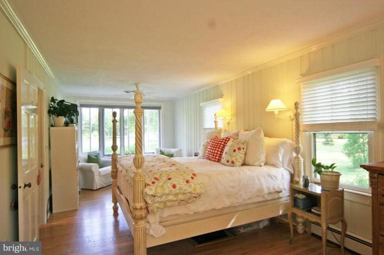 6857 Edge Creek Road St. Michaels, MD 21663 - Photo 5 of 13 a bedroom with a bed couch and a large window