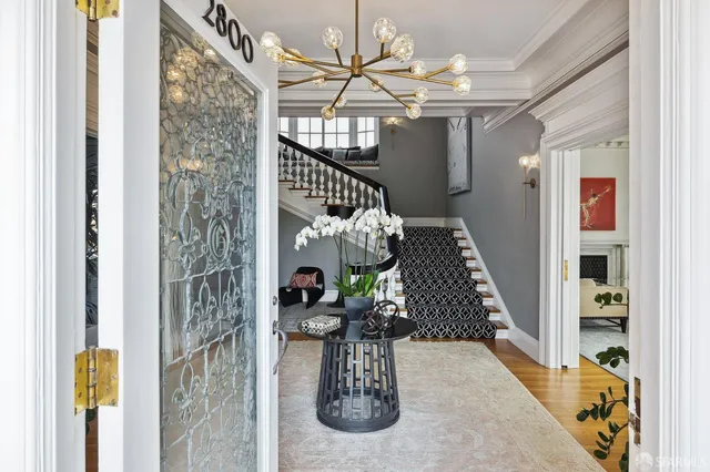 a vase of flowers sitting on a table with a chandelier