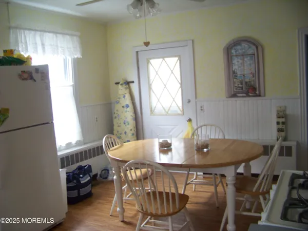 a room with a flat screen tv on dresser and a window