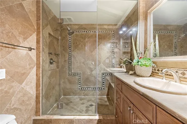 a bathroom with a granite countertop shower sink and mirror