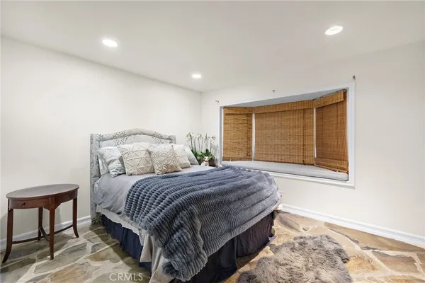 a bedroom with a large bed and a window