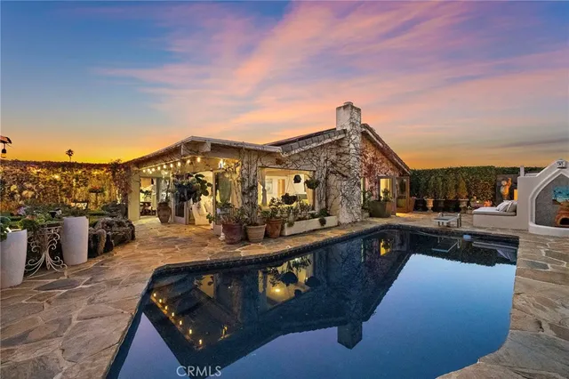 a view of a house with swimming pool and sitting area