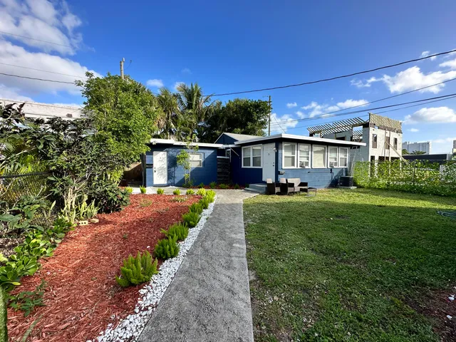 a front view of a house with a yard and outdoor seating