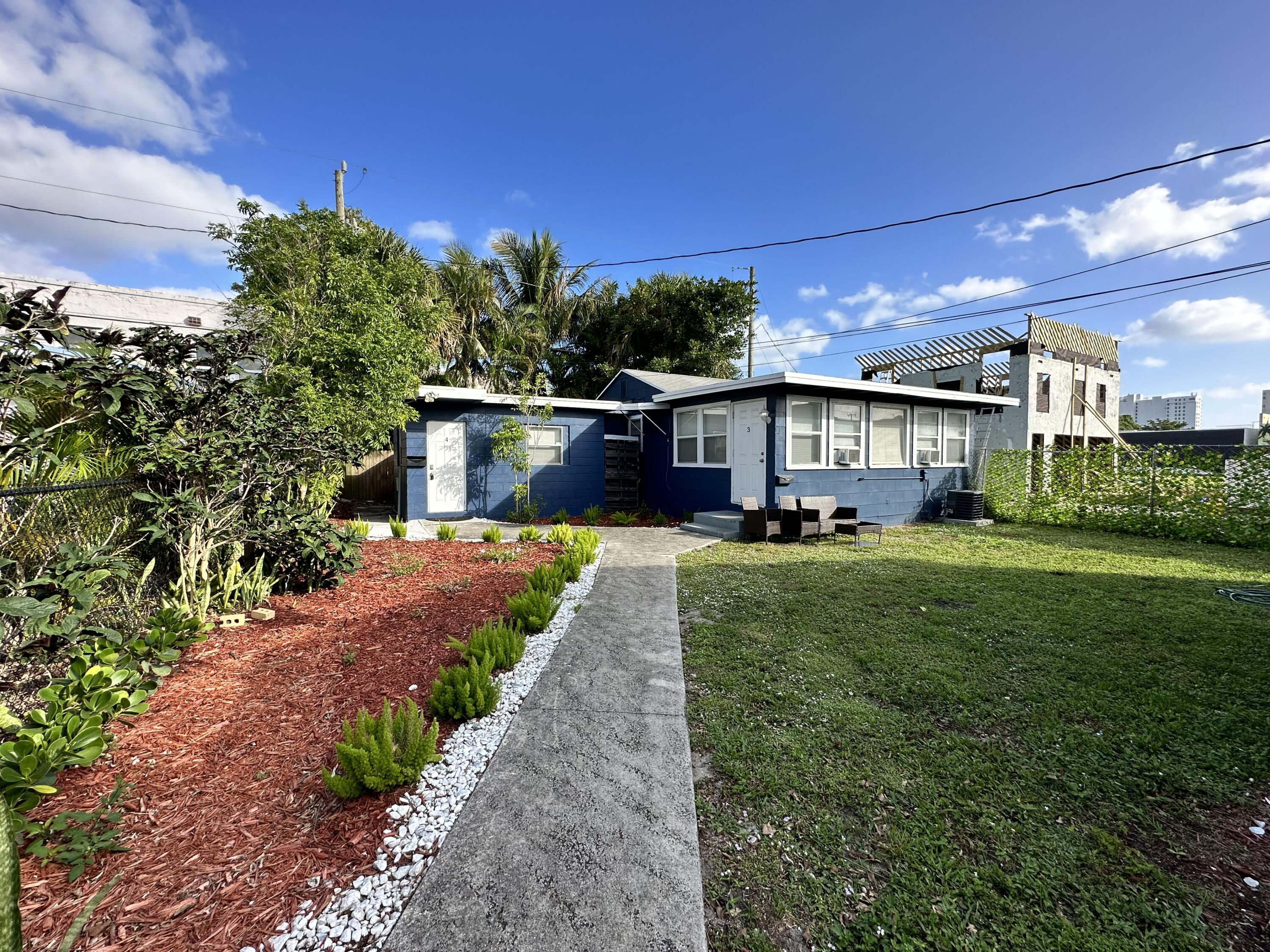 517 Kanuga Drive, Unit 4 West Palm Beach, FL 33401 - Photo 2 of 9 a front view of a house with a yard and outdoor seating