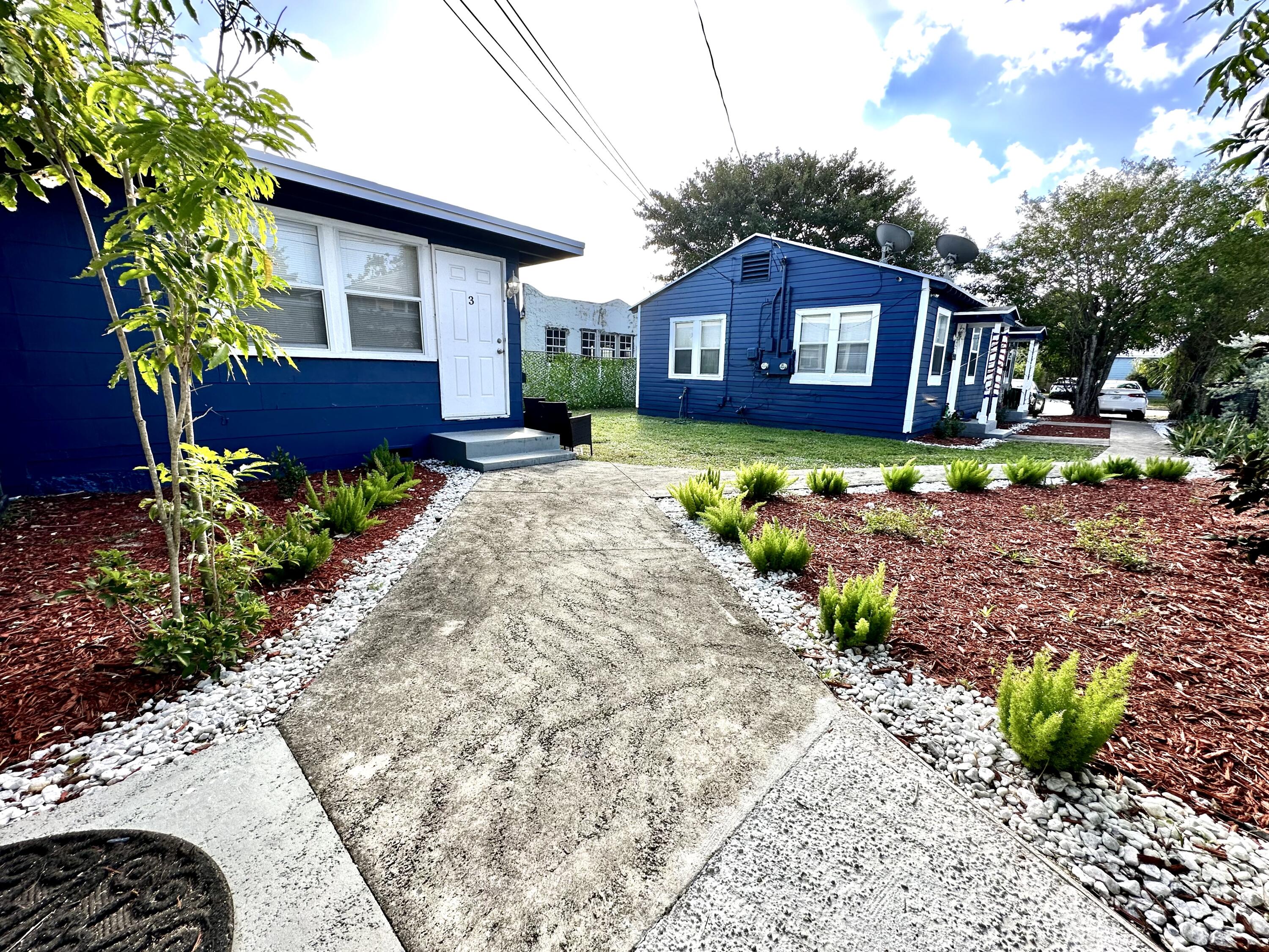 517 Kanuga Drive, Unit 4 West Palm Beach, FL 33401 - Photo 3 of 9 a front view of a house with a yard