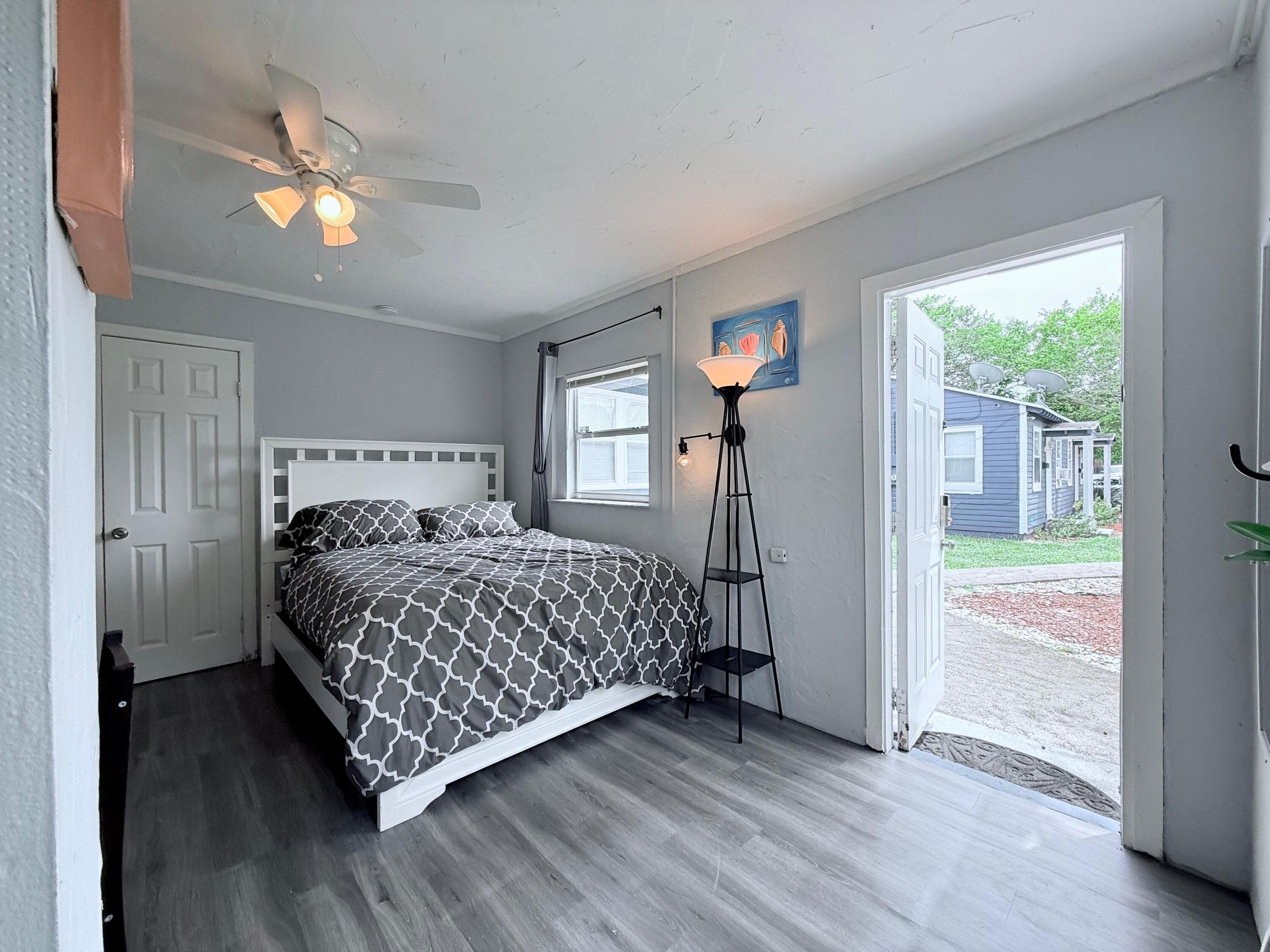 517 Kanuga Drive, Unit 4 West Palm Beach, FL 33401 - Photo 7 of 9 a bedroom with a bed and a chandelier