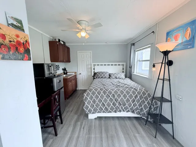 a bedroom with a bed a flat screen tv and a chandelier