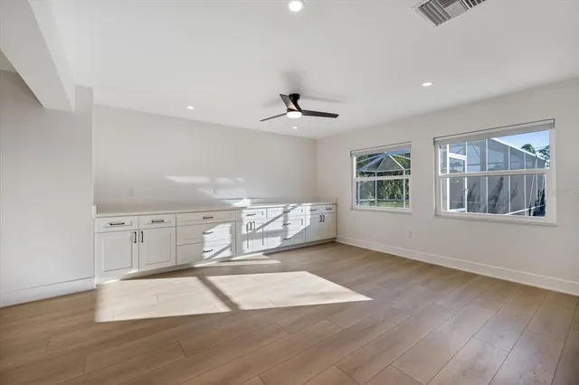 a view of an empty room with a window and a ceiling fan