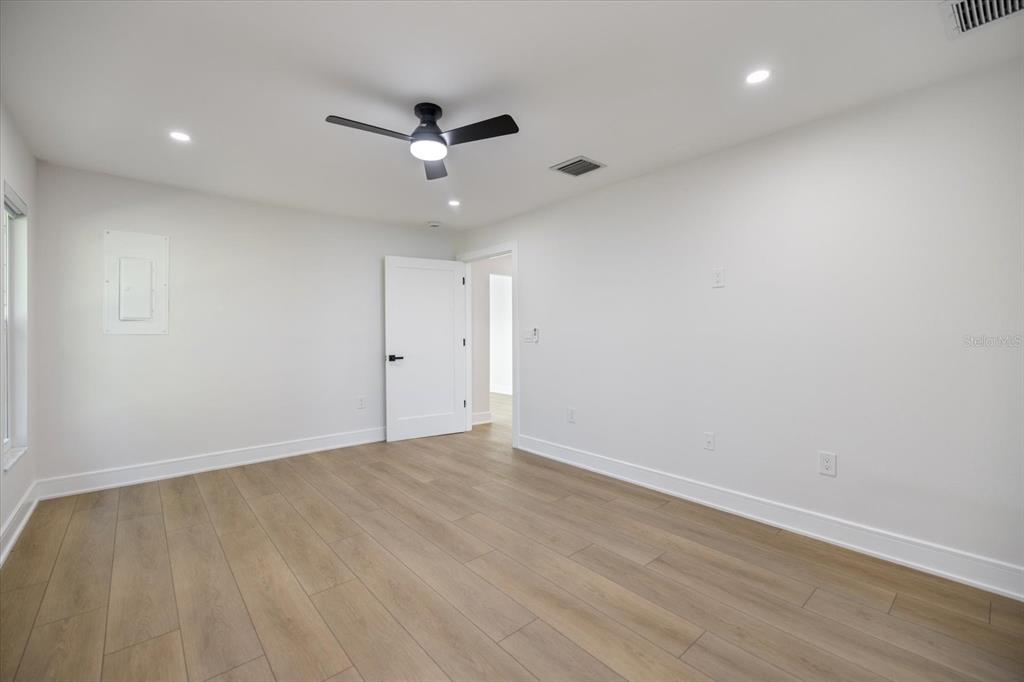 470 Leger Drive Nokomis, FL 34275 - Photo 17 of 51 an empty room with wooden floor and a ceiling fan