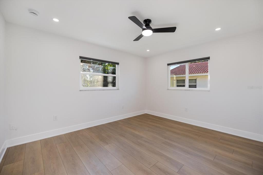470 Leger Drive Nokomis, FL 34275 - Photo 24 of 51 an empty room with wooden floor fan and windows