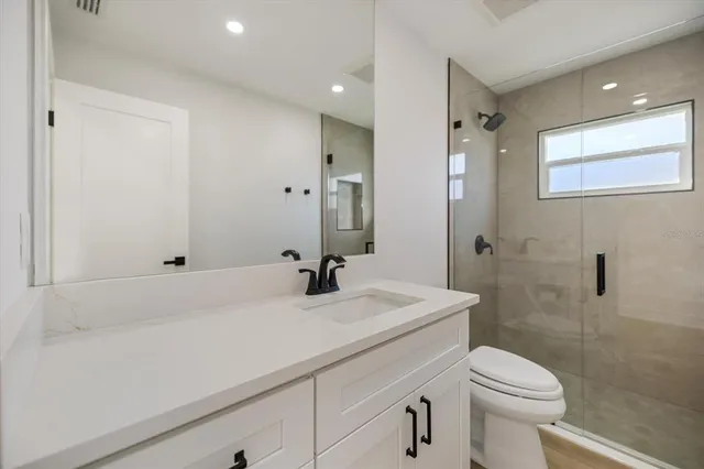 an empty room with wooden floor ceiling fan and windows