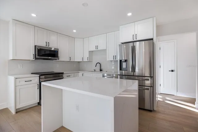 a kitchen with cabinets stainless steel appliances and a counter top space