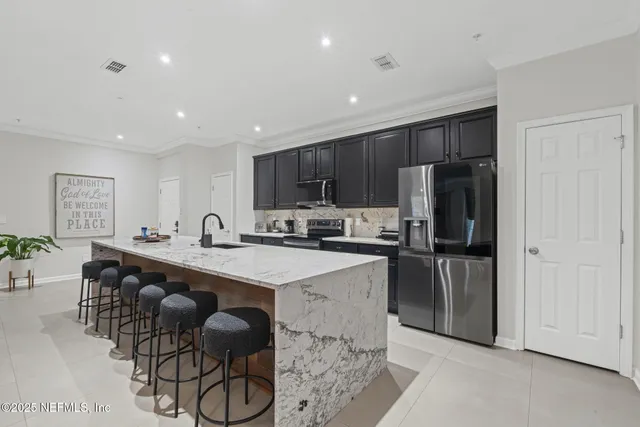 a large kitchen with a stove a sink a refrigerator and a refrigerator