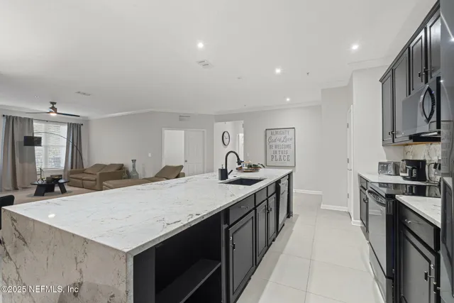 a kitchen with kitchen island granite countertop a sink and cabinets