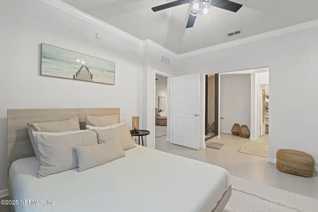 a bedroom with a bed a chair and a large window