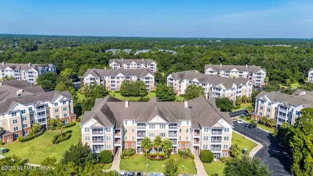 an aerial view of residential houses with outdoor space and trees