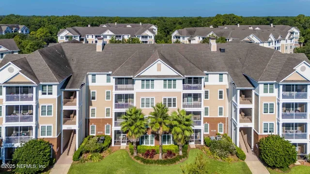 a front view of a multi story residential apartment building with a yard