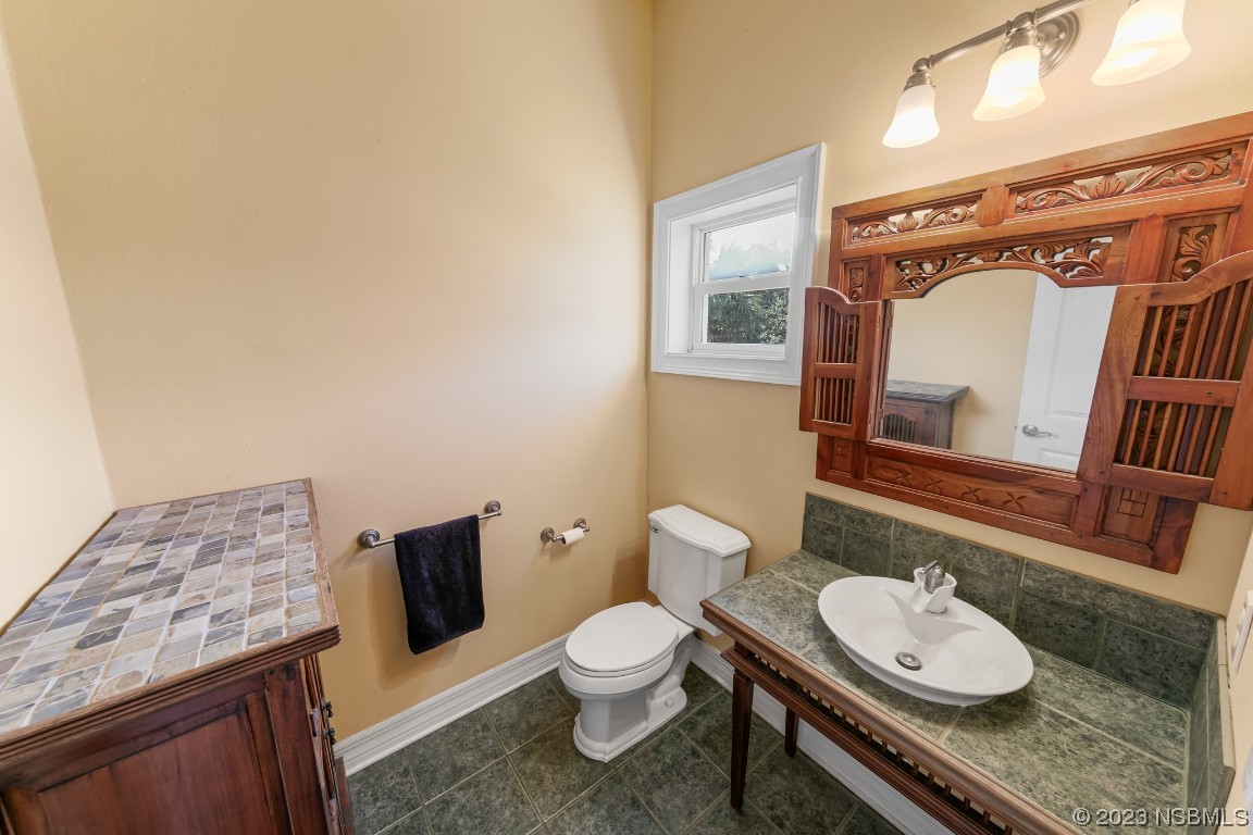 33 Calumet Avenue Ponce Inlet, FL 32127 - Photo 17 of 48 a bathroom with a granite countertop toilet sink and mirror