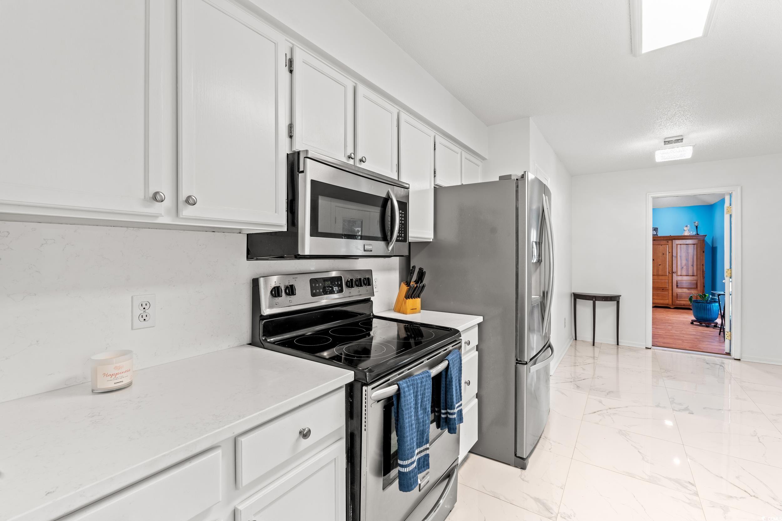 3056 Sweetpine Lane Conway, SC 29527 - Photo 11 of 36 Kitchen featuring appliances with stainless steel finishes, white cabinetry, light marble finish flooring, and light stone countertops