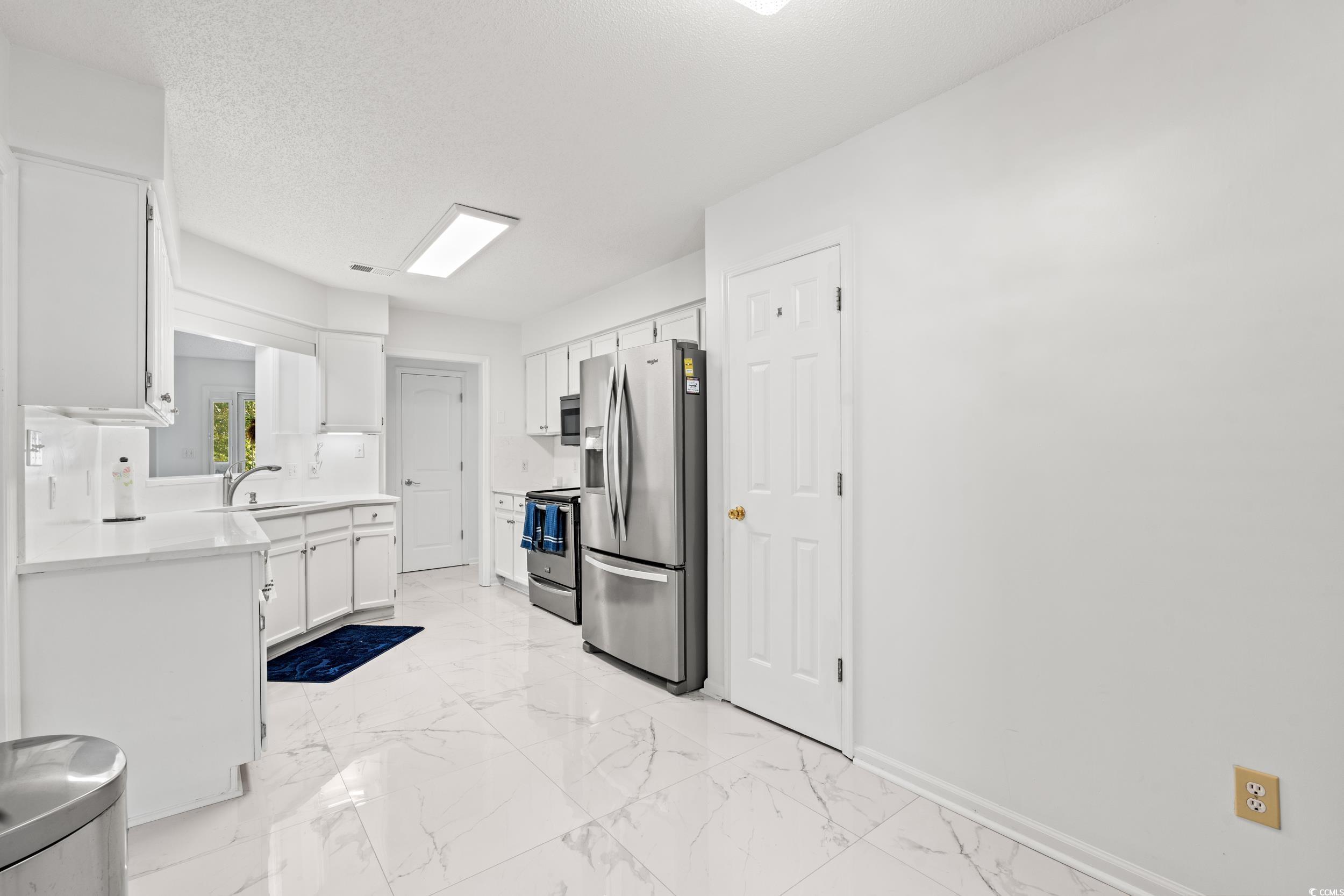 3056 Sweetpine Lane Conway, SC 29527 - Photo 13 of 36 Kitchen featuring white cabinetry, appliances with stainless steel finishes, a textured ceiling, and light marble finish floors