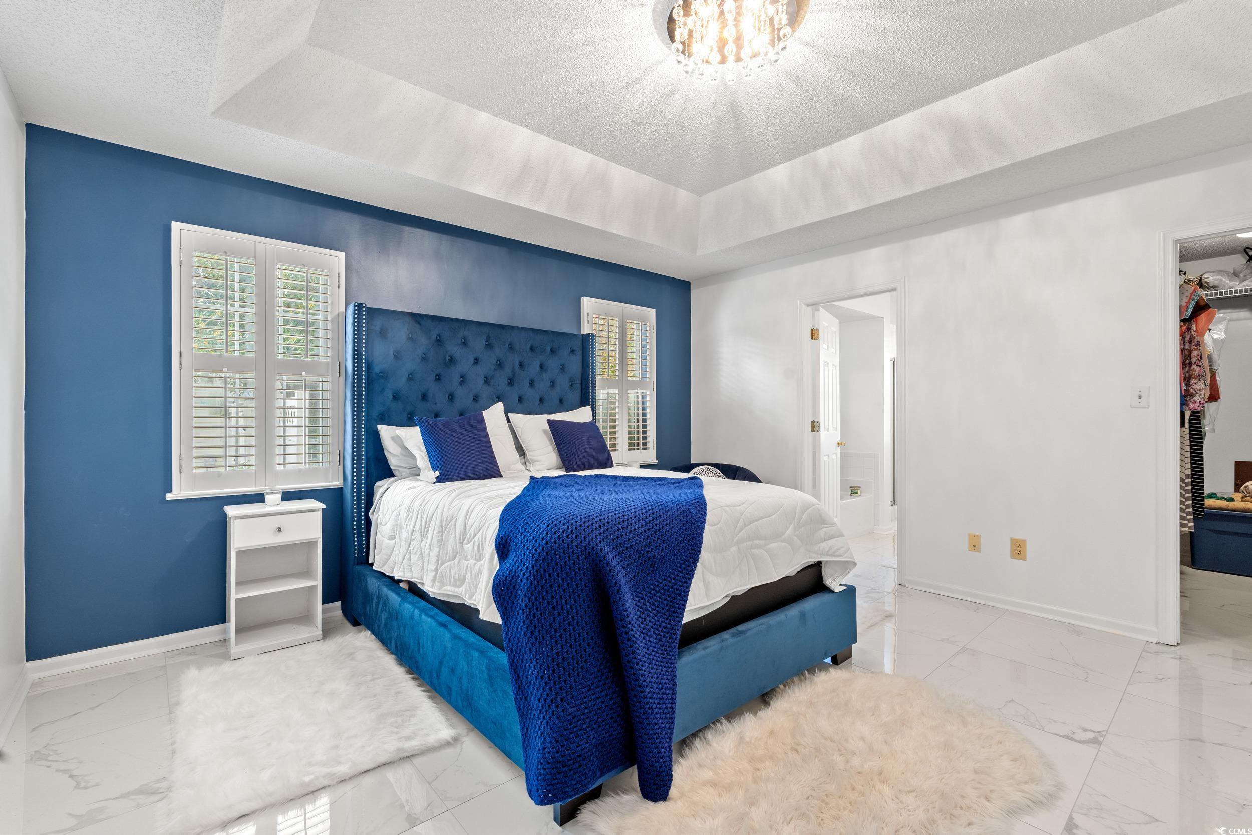 3056 Sweetpine Lane Conway, SC 29527 - Photo 23 of 36 Bedroom with marble look tile flooring, a tray ceiling, and a textured ceiling