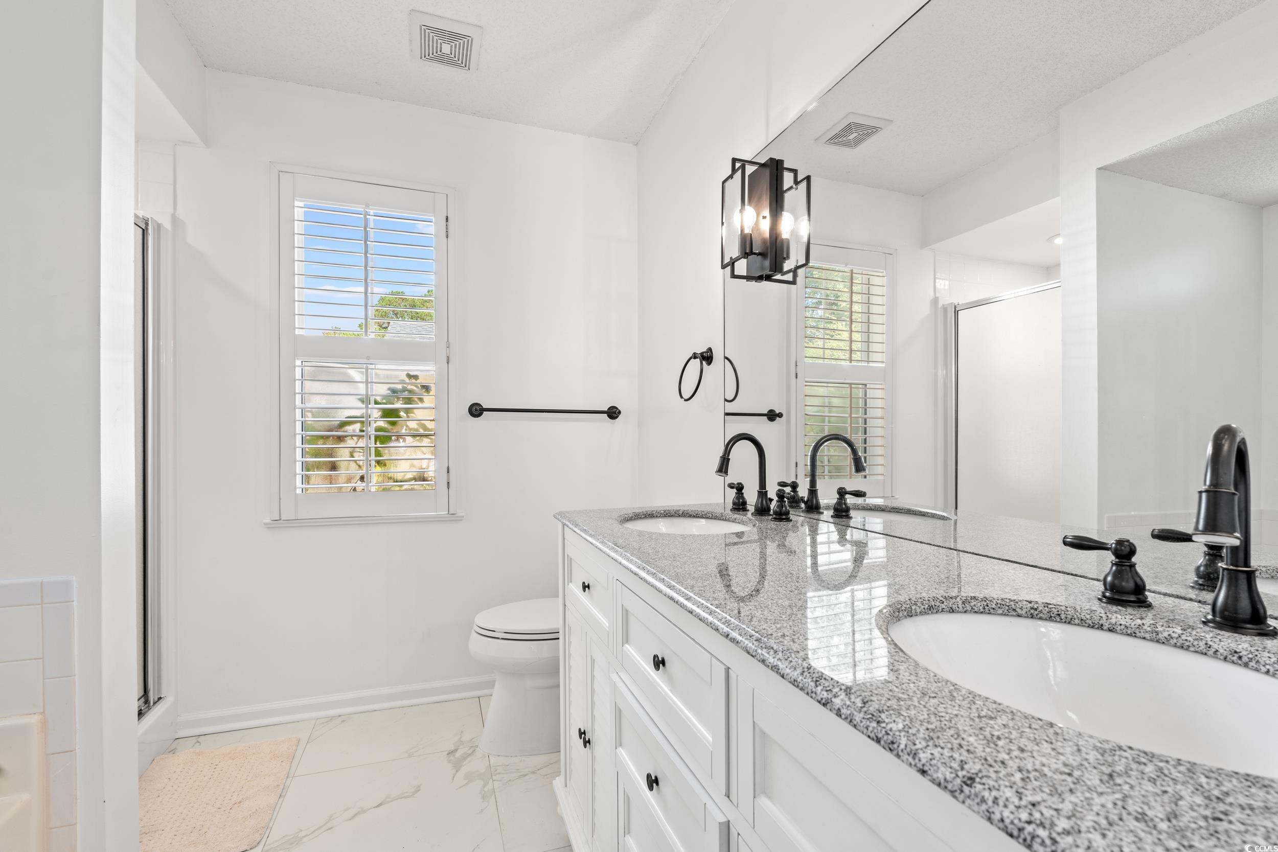 3056 Sweetpine Lane Conway, SC 29527 - Photo 26 of 36 Full bathroom with double vanity, a shower stall, light marble finish flooring, and a chandelier