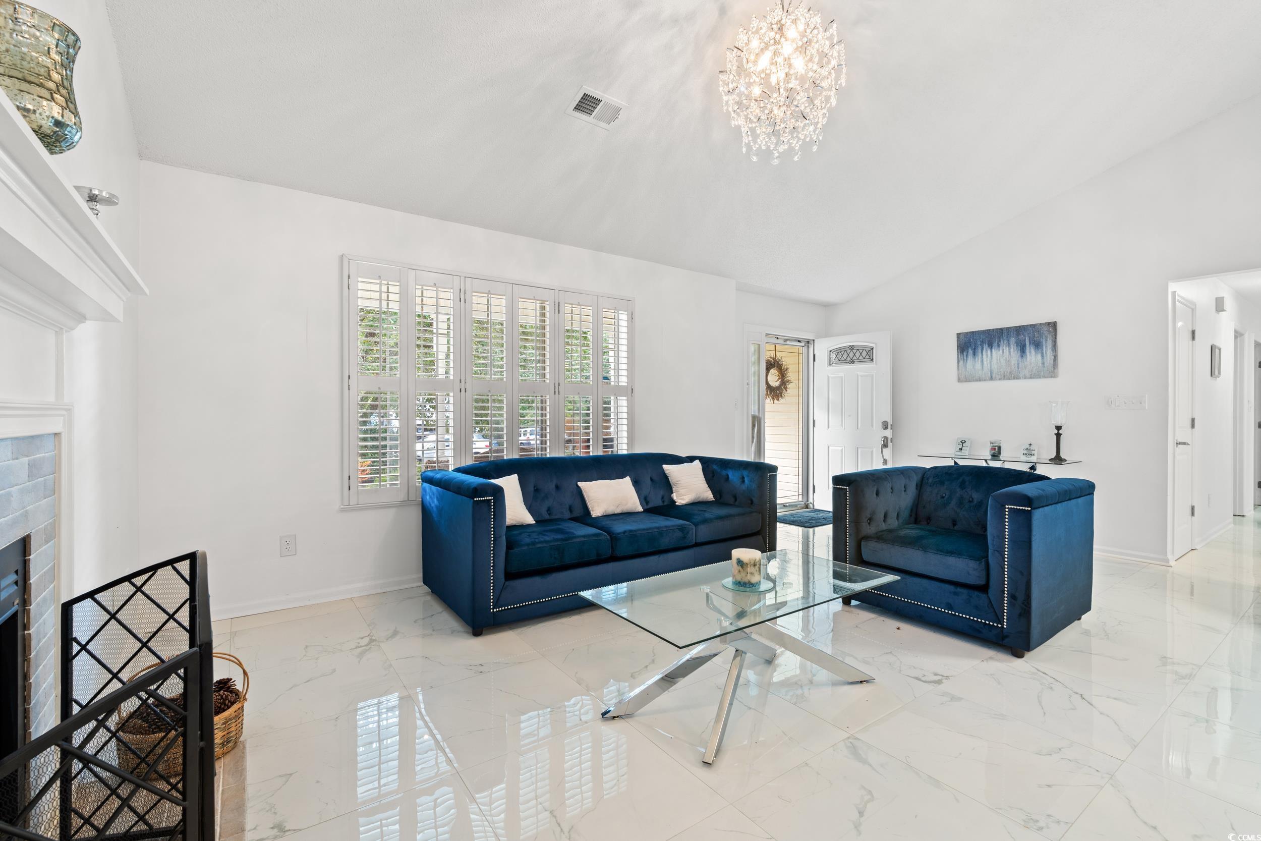3056 Sweetpine Lane Conway, SC 29527 - Photo 8 of 36 Living area with vaulted ceiling, light marble finish floors, a fireplace, and a chandelier