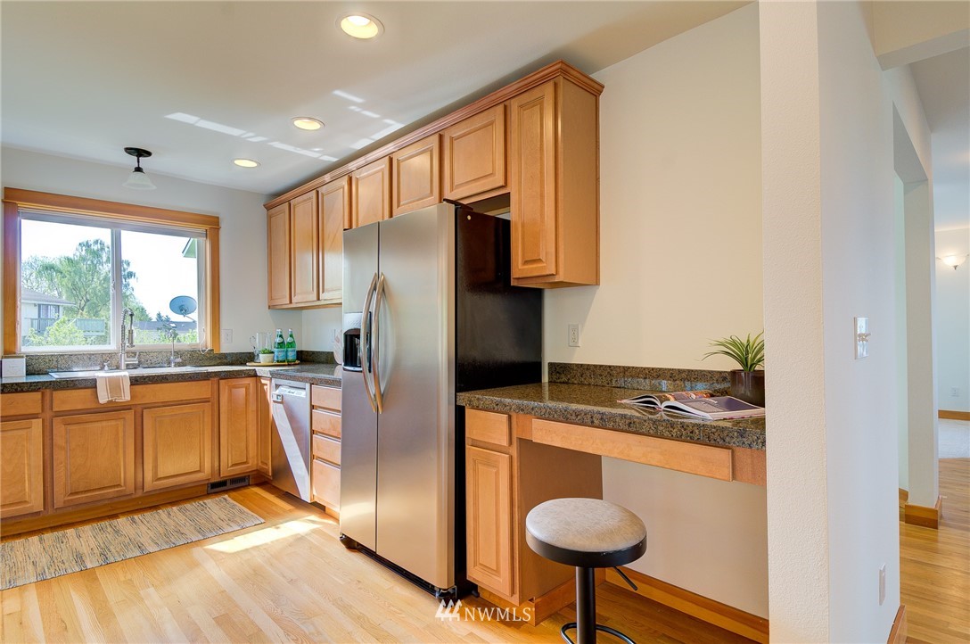 6734 Mars Avenue South Seattle, WA 98108 - Photo 12 of 40 a kitchen with stainless steel appliances granite countertop a sink a stove and a refrigerator
