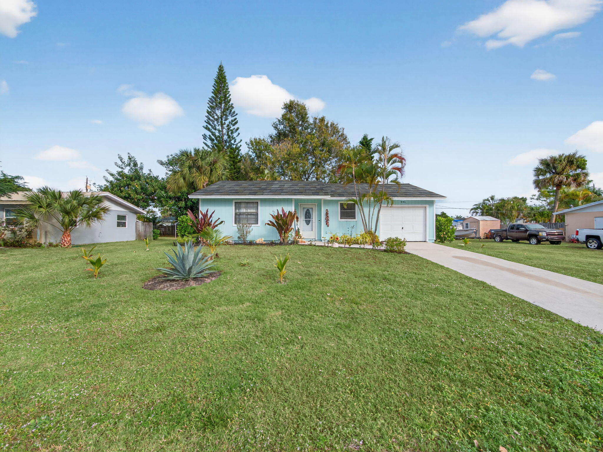 a front view of a house with a yard and potted plants