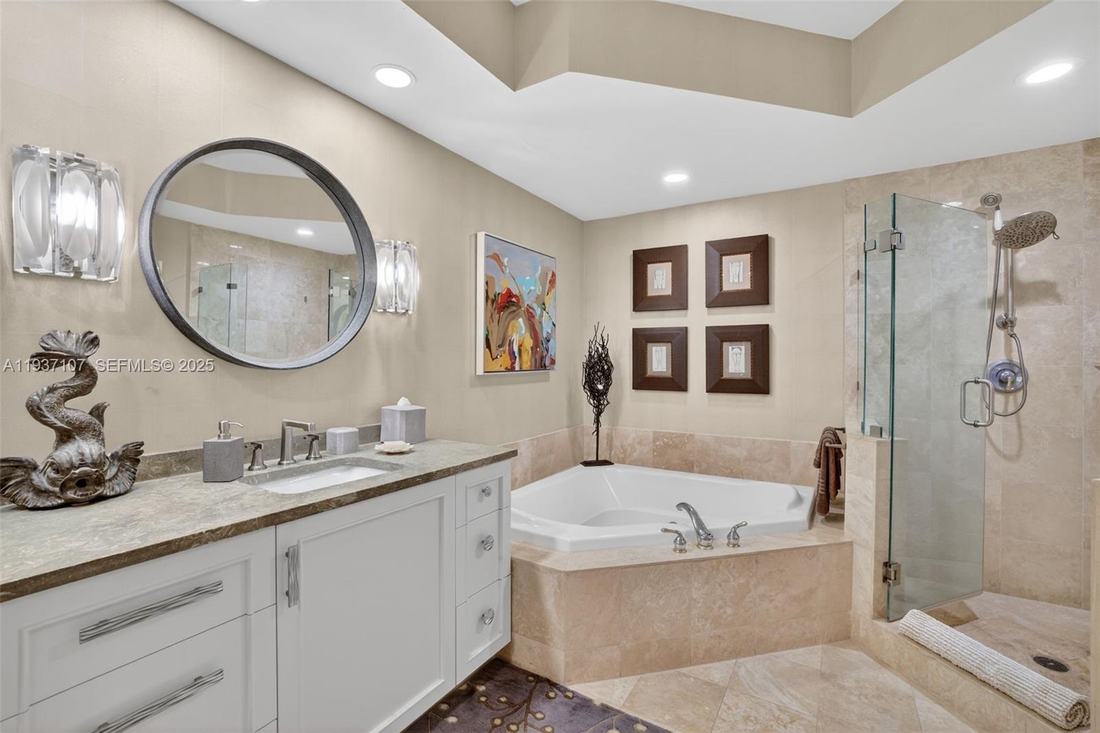 100 South Birch Road, Unit 1103F Fort Lauderdale, FL 33316 - Photo 43 of 80 Primary bathroom w/ custom wood vanity & upgraded hardware. Beautiful stone vanity counter, wall coverings, sconces, separate jetted tub & shower