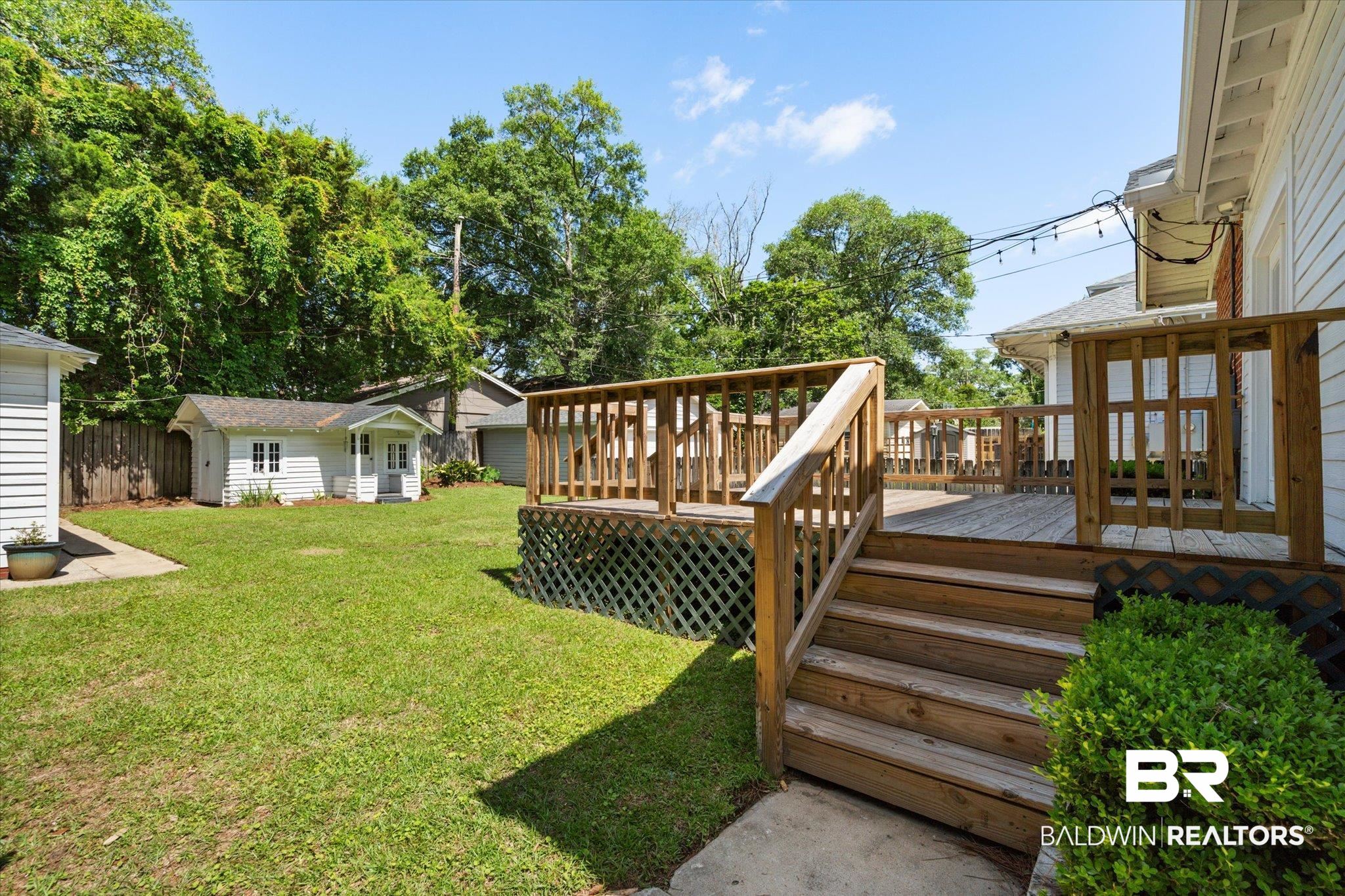 24 Macy Place Mobile, AL 36604 - Photo 35 of 38 View of green lawn featuring a deck and an outdoor structure
