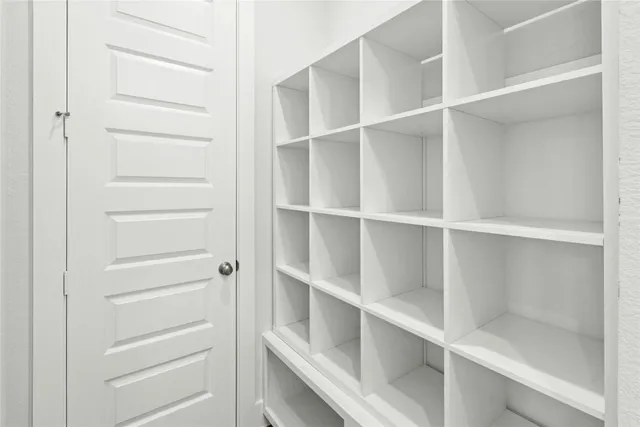 a view of walk in closet with empty racks