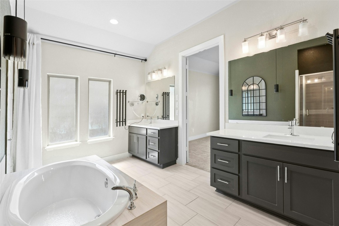 1121 Spring Gulch Lane Georgetown, TX 78628 - Photo 17 of 33 a bathroom with a tub sink and mirror