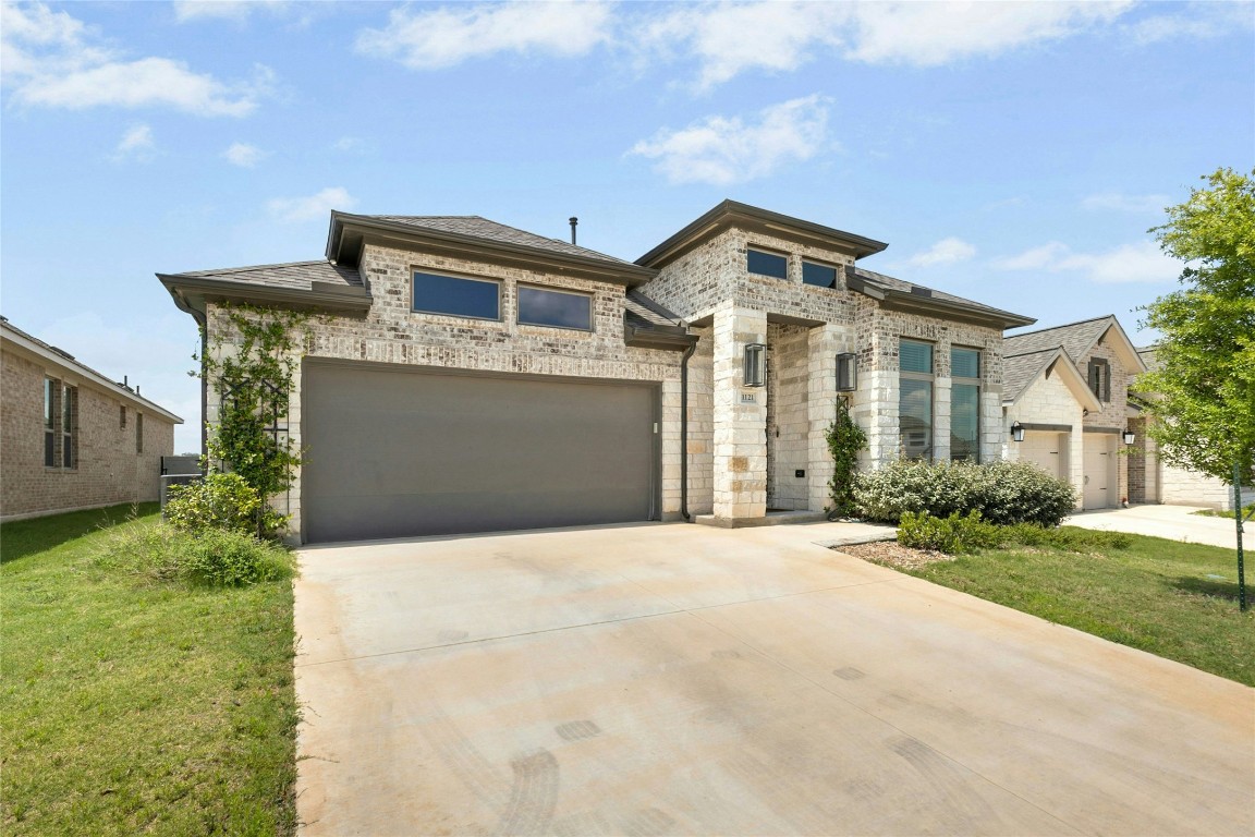 1121 Spring Gulch Lane Georgetown, TX 78628 - Photo 2 of 33 a front view of a house with a yard and garage