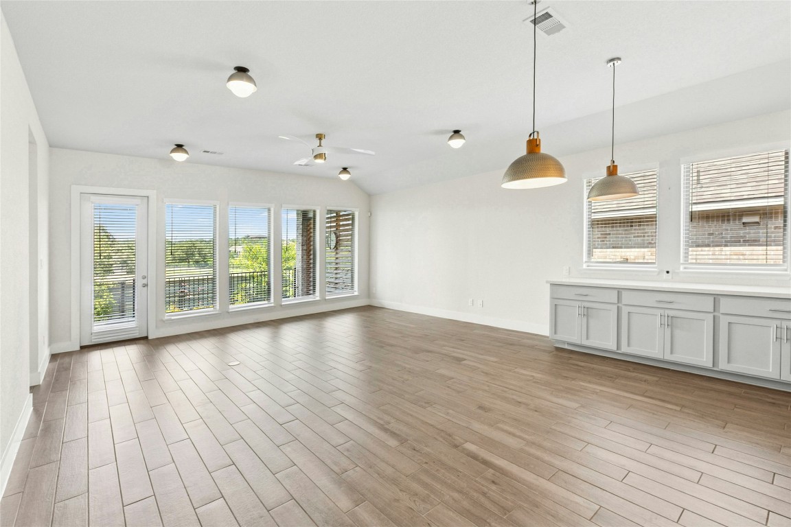 1121 Spring Gulch Lane Georgetown, TX 78628 - Photo 5 of 33 a view of an empty room with a window and wooden floor