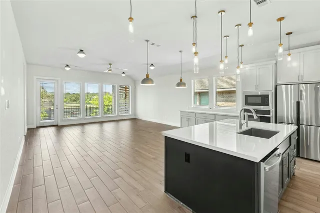 a open kitchen with kitchen island a sink stove and wooden floor