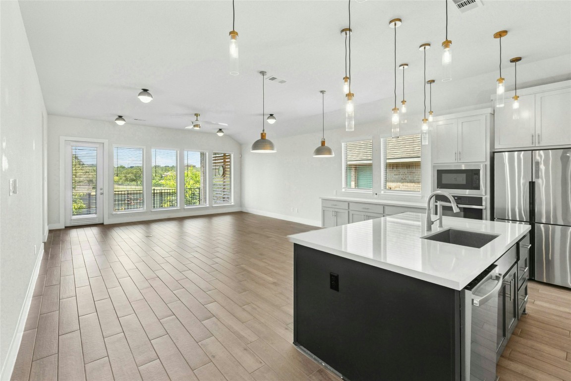 1121 Spring Gulch Lane Georgetown, TX 78628 - Photo 8 of 33 a open kitchen with kitchen island a sink stove and wooden floor