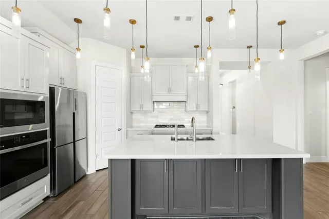 a kitchen with stainless steel appliances a refrigerator and a stove