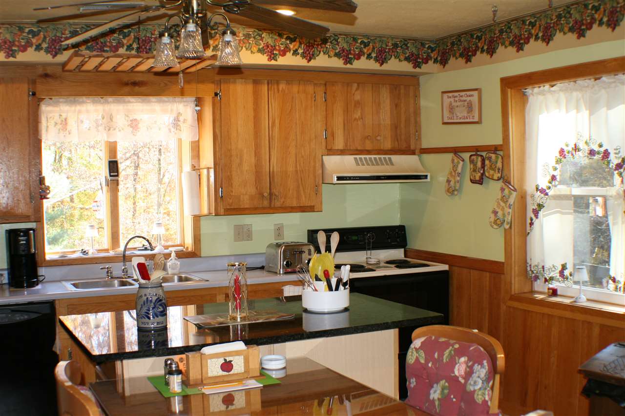 423 Rochelle School Lane Rochelle, VA 22738 - Photo 3 of 21 a kitchen with a stove a sink and a dining table with chairs