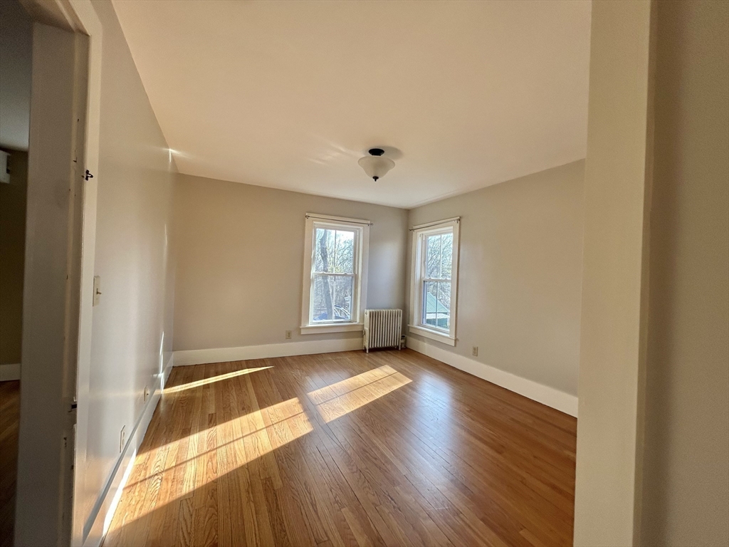 48 Congress Street Greenfield, MA 01301 - Photo 14 of 36 a view of an empty room with window and wooden floor